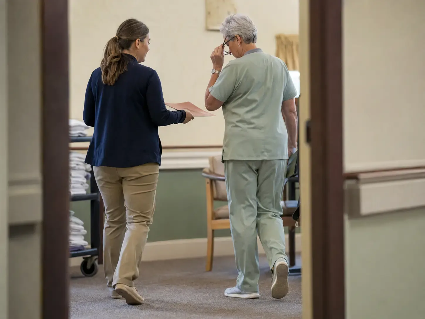 An admissions coordinator briefing a nursing director during a human handoff