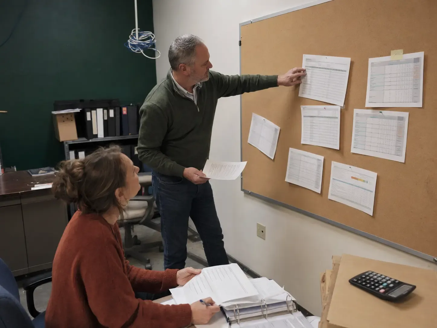 Two community leaders comparing software requirements on a temporary project board
